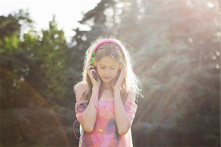 sunny day - Teenage girl wearing headphones in sunlight Stock Photo - Premium Royalty-Free, Code: 649-06845010
