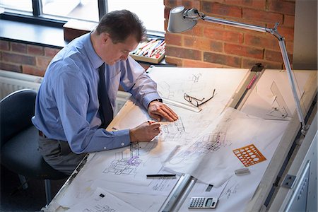 Architect drawing plans at drawing board Photographie de stock - Premium Libres de Droits, Code: 649-06845054