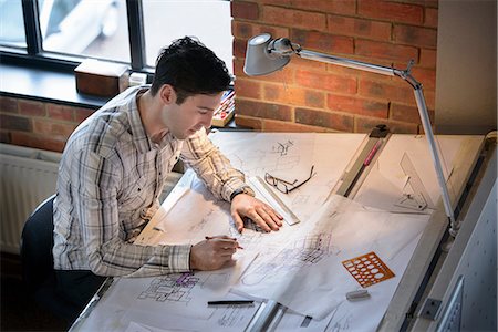 Architect drawing plans at drawing board Stock Photo - Premium Royalty-Free, Code: 649-06845055