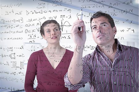 solutions - Mathematicians writing complex scientific equations on screen Stock Photo - Premium Royalty-Free, Code: 649-06845128