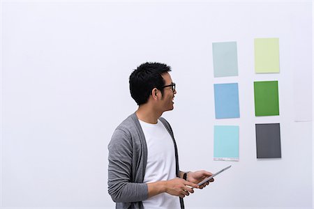 Young male designer looking at color swatch Stock Photo - Premium Royalty-Free, Code: 649-06845182