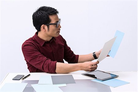 Young male designer looking at color swatch samples Stock Photo - Premium Royalty-Free, Code: 649-06845195