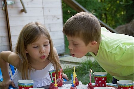 shack child - Brother and sister blowing out birthday candles Stock Photo - Premium Royalty-Free, Code: 649-06845252
