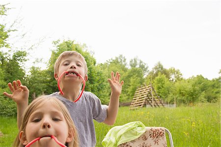 fun park mouth - Brother and sister biting on liquorice Stock Photo - Premium Royalty-Free, Code: 649-06845263