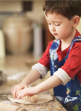 Child kneading dough with rolling pin Foto de stock - Sin royalties Premium, Código: 649-07064011