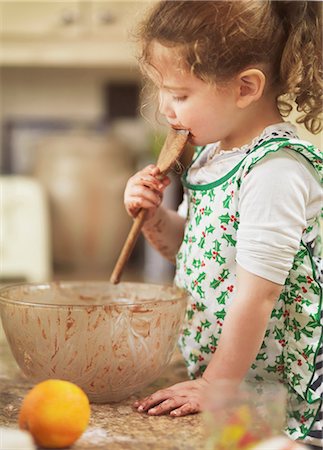 Child tasting cake mix with wooden spoon Photographie de stock - Premium Libres de Droits, Code: 649-07064012