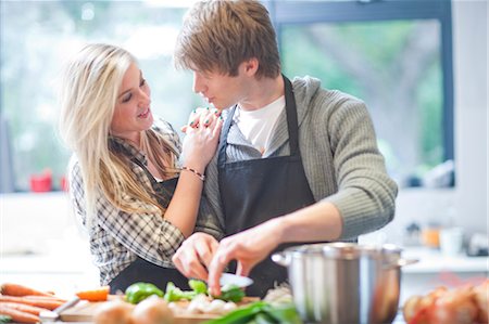 female with apron in kitchen - Affectionate young couple preparing food Stock Photo - Premium Royalty-Free, Code: 649-07064028