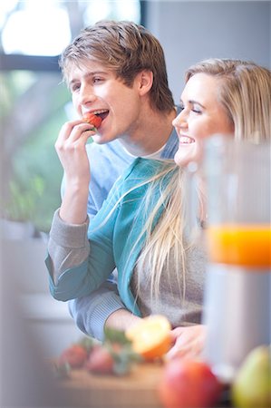 simsearch:649-08179955,k - Young couple eating fruit and preparing juice drink Fotografie stock - Premium Royalty-Free, Codice: 649-07064022