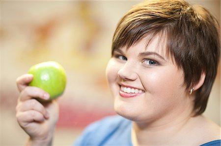 fett - Close up portrait of young woman holding apple Stockbilder - Premium RF Lizenzfrei, Bildnummer: 649-07064046