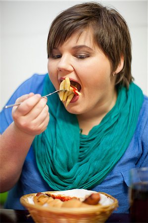 dick - Young woman in cafe eating fries Stockbilder - Premium RF Lizenzfrei, Bildnummer: 649-07064050