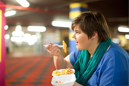 fett - Young woman eating takeaway fries Stockbilder - Premium RF Lizenzfrei, Bildnummer: 649-07064052