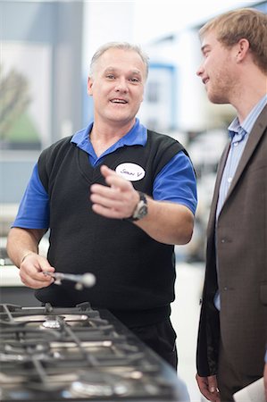 Young man negotiating with salesman in showroom Foto de stock - Sin royalties Premium, Código: 649-07064070