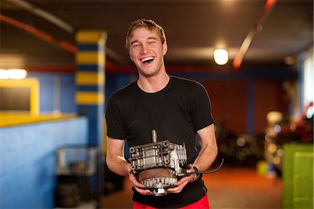 portrait young man mechanic - Mechanic holding engine in go cart workshop Stock Photo - Premium Royalty-Free, Code: 649-07064111