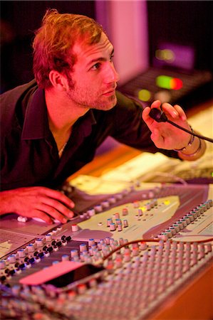 Young man on mixing desk Foto de stock - Sin royalties Premium, Código: 649-07064124