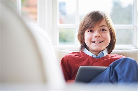 Boy on sofa using digital tablet Foto de stock - Sin royalties Premium, Código: 649-07064235