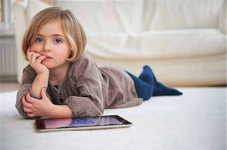 Girl lying on floor using digital tablet Foto de stock - Sin royalties Premium, Código: 649-07064264