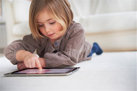 en pied - Girl lying on floor using digital tablet Photographie de stock - Premium Libres de Droits, Code: 649-07064267
