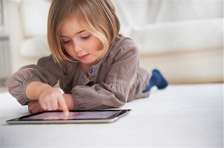 electronics - Girl lying on floor using digital tablet Stock Photo - Premium Royalty-Free, Code: 649-07064267