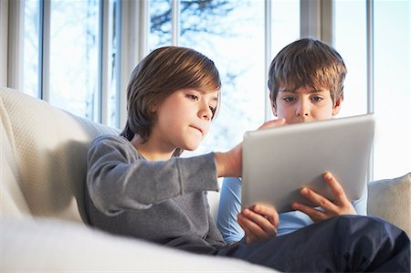 siblings sofa - Brothers using digital tablet together Stock Photo - Premium Royalty-Free, Code: 649-07064278