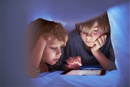 secret photo of boys - Brothers underneath duvet using digital tablet Stock Photo - Premium Royalty-Free, Code: 649-07064285