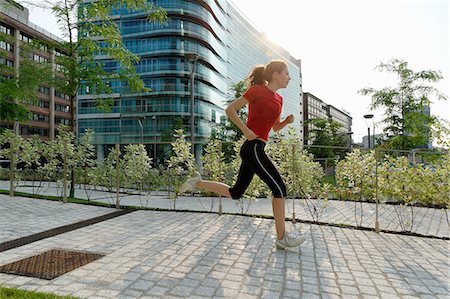 ponytail sideview - Young woman running past office buildings Foto de stock - Sin royalties Premium, Código: 649-07064318