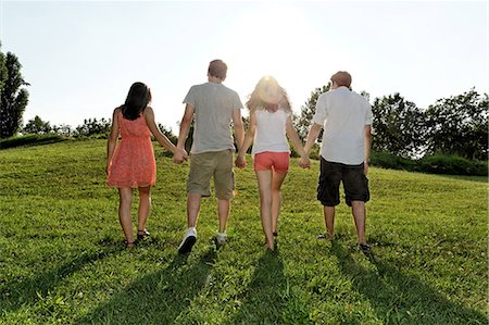 energetic woman walking - Group of young adults walking and holding hands Stock Photo - Premium Royalty-Free, Code: 649-07064335