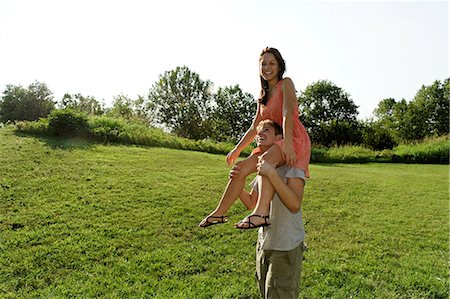 simsearch:614-08329434,k - Young woman sitting on young mans shoulders Foto de stock - Sin royalties Premium, Código: 649-07064330