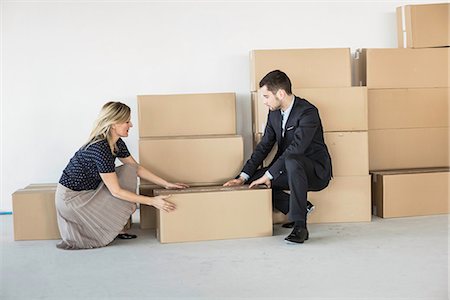 Businessman and -woman lifting cardboard box Foto de stock - Sin royalties Premium, Código: 649-07064427