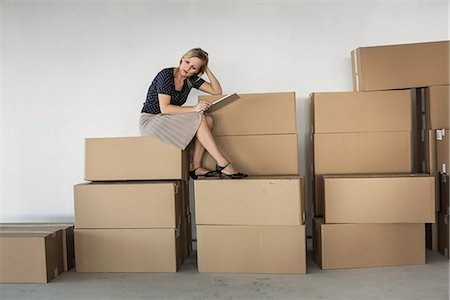 simsearch:649-07064416,k - Businesswoman sitting on stack of cardboard boxes Stock Photo - Premium Royalty-Free, Code: 649-07064433