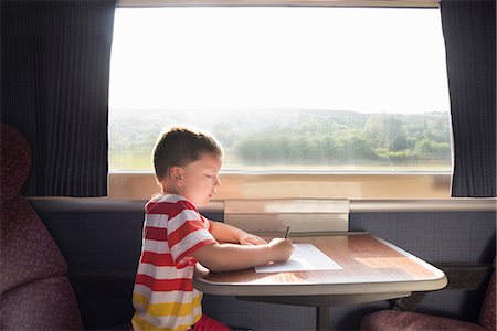 Young boy with pencil and paper on train Foto de stock - Sin royalties Premium, Código: 649-07064441