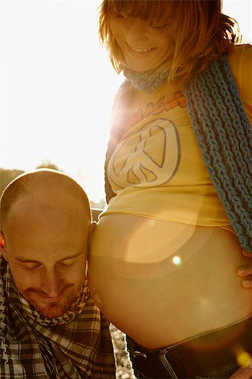 Pregnant woman with partner's cheek on bump Photographie de stock - Premium Libres de Droits, Le code de l’image : 649-07064575