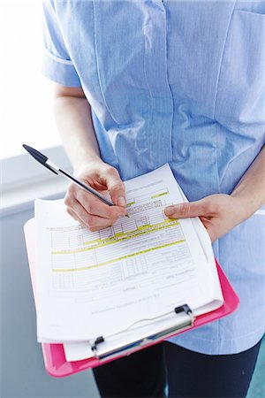 paperasserie - Mid-section of nurse writing paperwork Photographie de stock - Premium Libres de Droits, Code: 649-07064702