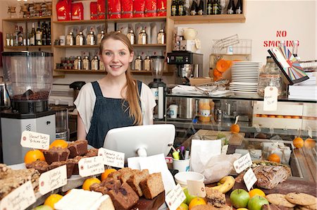 Young woman behind kitchen counter in cafe Stock Photo - Premium Royalty-Free, Code: 649-07064877