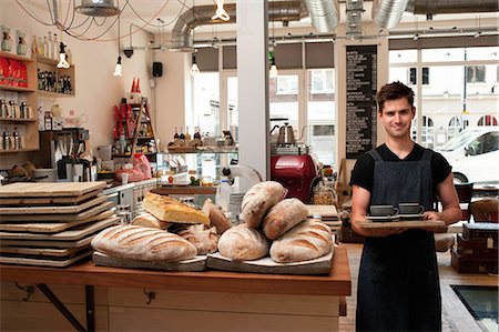 simsearch:614-06624461,k - Portrait of young man carrying tray in cafe Stock Photo - Premium Royalty-Free, Code: 649-07064889