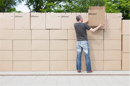 pappkarton - Man building wall of cardboard boxes Foto de stock - Sin royalties Premium, Código: 649-07064895