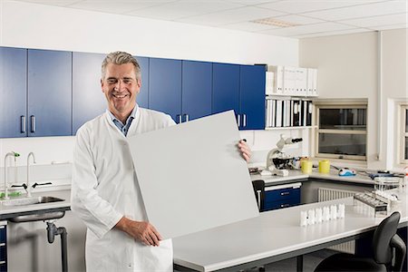 Male scientist in laboratory with blank sign Stock Photo - Premium Royalty-Free, Code: 649-07065319