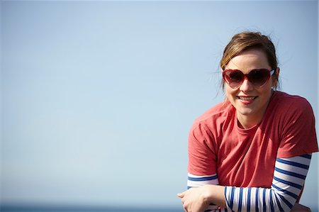 red sunglasses - Portrait of young woman wearing heart shape sunglasses at coast Stock Photo - Premium Royalty-Free, Code: 649-07063004