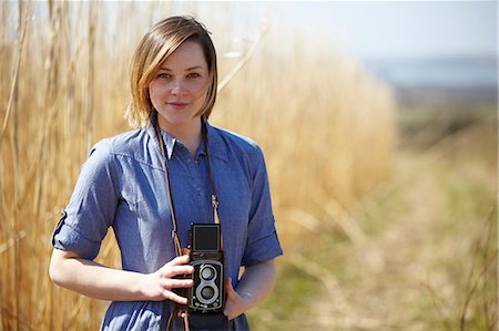fotógrafos - Close up portrait of young woman holding camera Foto de stock - Sin royalties Premium, Código: 649-07063003