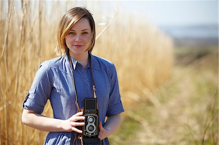 reed - Close up portrait of young woman holding camera Stock Photo - Premium Royalty-Free, Code: 649-07063003