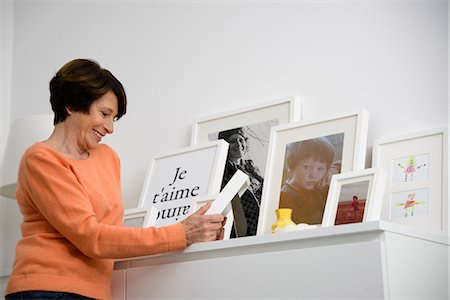 framed pictures at home - Senior woman looking at family photographs Stock Photo - Premium Royalty-Free, Code: 649-07063039