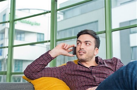 Young man at home using his mobile phone Foto de stock - Sin royalties Premium, Código: 649-07063164