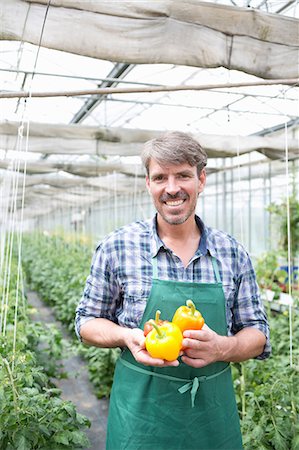 production (manufacturing) - Portrait of organic farmer holding yellow peppers Stock Photo - Premium Royalty-Free, Code: 649-07063428