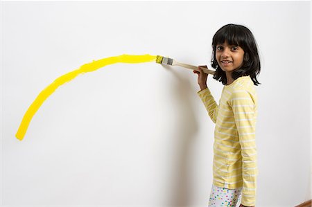 Portrait of girl painting yellow curve on wall Foto de stock - Sin royalties Premium, Código: 649-07063430