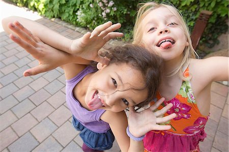 sacando la lengua - Two girls pulling faces Foto de stock - Sin royalties Premium, Código: 649-07063456