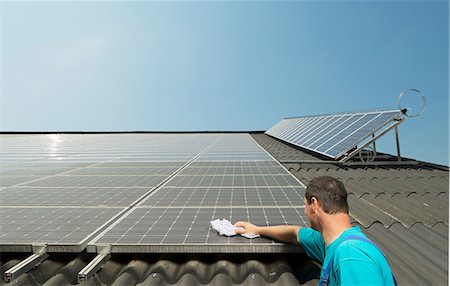 Farmer cleaning solar panels on barn roof, Waldfeucht-Bocket, Germany Stock Photo - Premium Royalty-Free, Code: 649-07063480