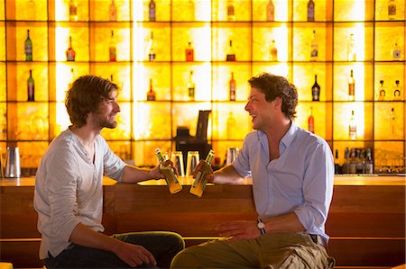 simsearch:649-07063515,k - Two men sitting at bar with bottles of beer Foto de stock - Sin royalties Premium, Código: 649-07063514