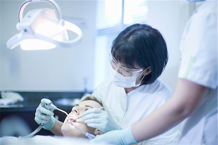 dentist clinic - Female dentist checking patients teeth Stock Photo - Premium Royalty-Free, Code: 649-07063601