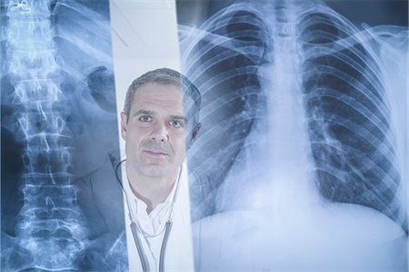 Doctor examining xray results displayed on screen Stock Photo - Premium Royalty-Free, Code: 649-07063672