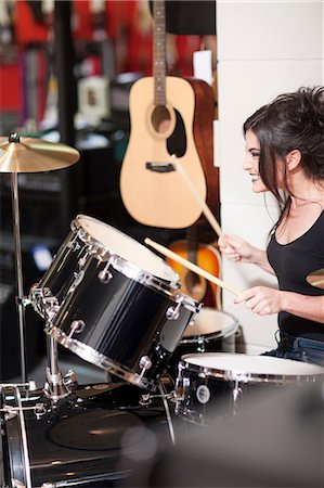 palillo de tambor - Young woman trying drum kit  in music store Foto de stock - Sin royalties Premium, Código: 649-07063815