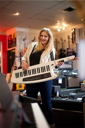 prétendre - Young woman playing keytar in music store Photographie de stock - Premium Libres de Droits, Code: 649-07063817
